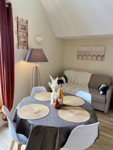 una sala de estar con una mesa con platos y un sofá en Résidence du Parad'Ice, en Dinard