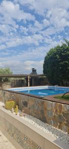 una gran piscina con una pared de piedra en Rancho Tropicana, en Elche