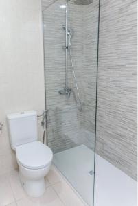 a bathroom with a toilet and a glass shower at GOLF PARK Resort in San Miguel de Abona