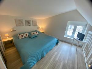 a bedroom with a blue bed with two pillows at Résidence du Parad'Ice in Dinard