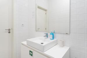 a white bathroom with a sink and a mirror at GuestReady - Almada 516 in Porto