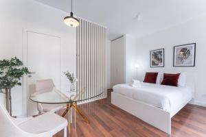 a white bedroom with a bed and a glass table at GuestReady - Almada 516 in Porto