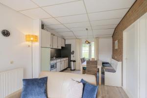 een woonkamer met een bank en een keuken bij De Duin Haven - Seinpost 03 - Callantsoog in Callantsoog