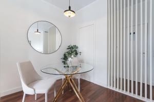 a dining room with a glass table and a mirror at GuestReady - Almada 516 in Porto