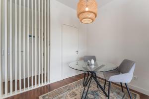 a dining room with a glass table and a chair at GuestReady - Almada 516 in Porto +16 photos