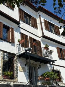 a white building with balconies and plants on it at Old Town Traditional Residence in Kavala
