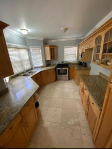 a large kitchen with wooden cabinets and a tile floor at ST Michael’s terrace in Kingston