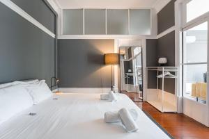Un dormitorio con una gran cama blanca con toallas. en GuestReady - Innvict Residences, en Oporto
