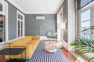 sala de estar con sofá amarillo y alfombra azul en GuestReady - Innvict Residences, en Oporto