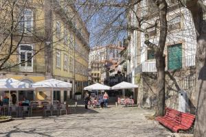 una calle de la ciudad con mesas, sillas y sombrillas en GuestReady - Innvict Residences, en Oporto