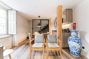 una cucina e una sala da pranzo con tavolo e sedie di GuestReady - Mercadores 150 a Porto Altre 27 foto