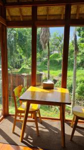 uma mesa de madeira e cadeiras num quarto com uma janela em RUMAH KAYU MATARAJA VILLA - TABANAN em Perean