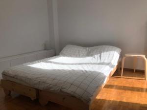 un piccolo letto in una stanza con sgabello di Sunny & Peaceful 55sq.m Flat nearby Piraeus Port a Pireo