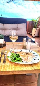 a plate of food and a glass of wine on a table at Selwo Studio in Estepona