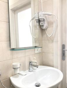 een badkamer met een witte wastafel en een spiegel bij Antigua Locazione turistica in Monopoli
