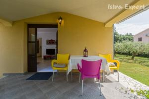 comedor con mesa y sillas coloridas en Apartment Susnjici 2 with Pool, Children Playground and Terrace, en Baderna
