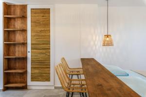a dining room with a wooden table and chairs at Emerald Bay 4BR with pool by Lia Beach in Mikonos +21 photos