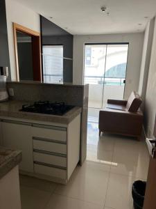 een keuken met een fornuis en een bank in een kamer bij Flat espetacular Flamboyant 2 in Goiânia