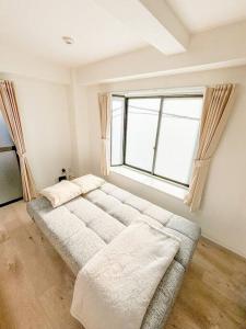 een groot bed in een kamer met een groot raam bij ゲストルーム上野桜木(上野駅and日暮里駅) in Tokyo