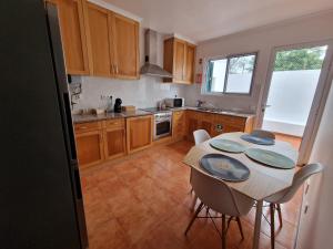 a kitchen with a table and some chairs and a kitchen with a counter at Wild Blue By SVL in Ponta Delgada