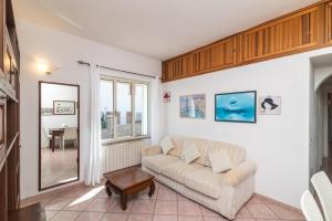 uma sala de estar com um sofá e uma mesa em LA TERRAZZA SULL'INSENATURA em Santa Teresa Gallura