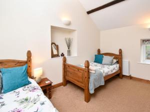 a bedroom with two beds and a mirror at 2 bed property in Whitton Northumberland 61267 in Rothbury