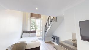 Habitación blanca con cama y TV en MSK Elite, en Londres
