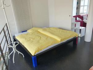 a bed with a yellow blanket on it in a room at Ferienhaus am Kletterturm in Waldstetten