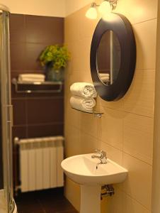een badkamer met een wastafel en een spiegel bij Pokoje gościnne Restauracja u Kusia in Mikołów