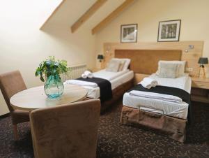 una habitación de hotel con 2 camas y una mesa con flores en Pokoje gościnne Restauracja u Kusia, en Mikołów