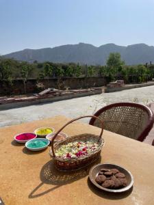 a table with a basket of candy and cookies on it at Farm Aavjo - A Conscious Stay in Pushkar
