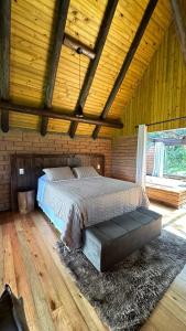 1 dormitorio con 1 cama en una habitación de madera en Maria Rita dos Canyons, en Praia Grande