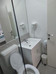 a bathroom with a white toilet and a sink at Bedaleyl in Piteşti