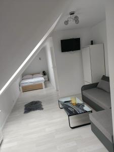 a white living room with a couch and a table at Dom Marek in Wisełka