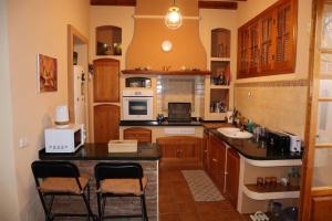 een keuken met een aanrecht en twee krukken. bij Preciosa casa en Carratraca in Carratraca