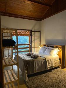 1 dormitorio con litera y ventana en Sitio Por do Sol - Hospedagem, en Delfim Moreira