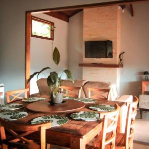un tavolo da pranzo con una pianta sopra di Sitio Por do Sol - Hospedagem a Delfim Moreira