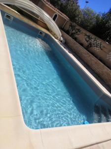 uma piscina com água azul num quintal em 2 Chambres avec piscine et spa au calme, mer à proximité. em Portiragnes