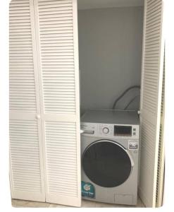 a washing machine in a closet with a door at ST Michael’s terrace in Kingston