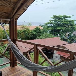 a hammock on the deck of a house at La Posada del Gecko in Capurganá