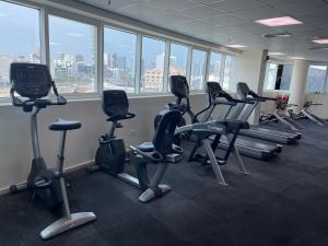a gym with treadmills and ellipticals in a room with windows at Purity Inn JVC in Dubai