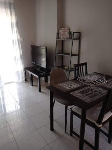 a living room with a table and a television at Διαμέρισμα με θέα σε πάρκο! in Serres