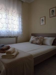1 cama con 2 toallas en un dormitorio en Διαμέρισμα με θέα σε πάρκο!, en Serres