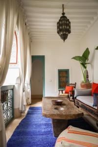 a living room with a table and a couch at Riad 11 Zitoune in Marrakech