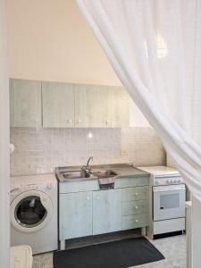 uma cozinha com um lavatório e uma máquina de lavar roupa em Palazzo San Pietro Casa Vacanze a 2 passi da Lecce em San Pietro in Lama