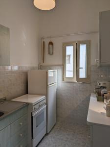 uma cozinha com um frigorífico branco e uma janela em Palazzo San Pietro Casa Vacanze a 2 passi da Lecce em San Pietro in Lama