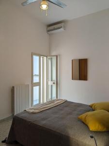 um quarto branco com uma cama e uma janela em Palazzo San Pietro Casa Vacanze a 2 passi da Lecce em San Pietro in Lama
