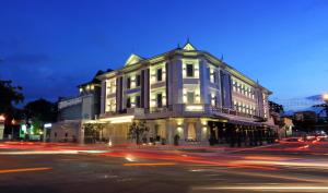 a large white building on a street at night at Arunreas Hotel in Phnom Penh