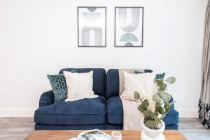 a blue couch in a living room with a table at Tower Bridge & Liverpool Street - CityApartmentStay in London
