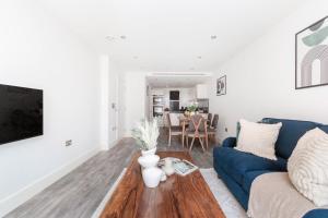 sala de estar con sofá azul y mesa en Tower Bridge & Liverpool Street - CityApartmentStay en Londres